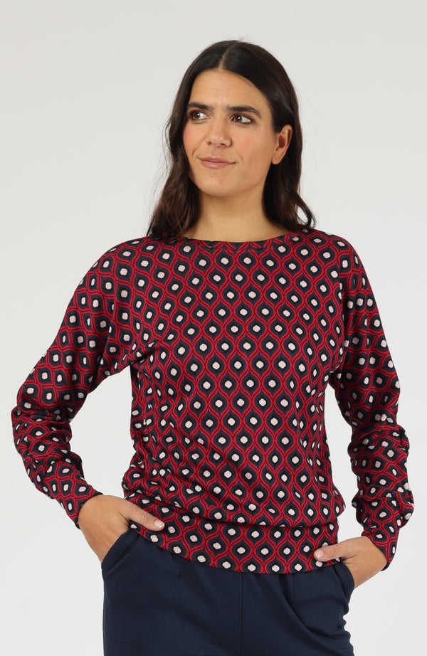 Gemusterter Langarm-Pullover in Bordeaux-Rot mit U-Boot-Ausschnitt und Bündchen, kombiniert mit blauer Hose.