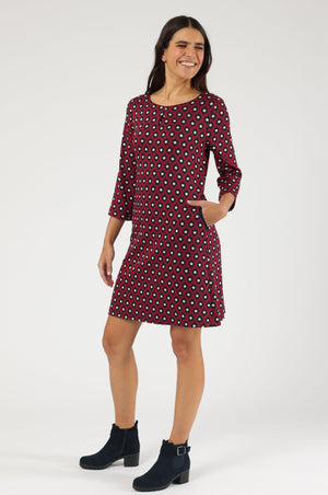 Knieumspielendes Kleid in Dunkelrot mit geometrischem Muster, 3/4-Ärmeln und praktischen seitlichen Eingriffstaschen.