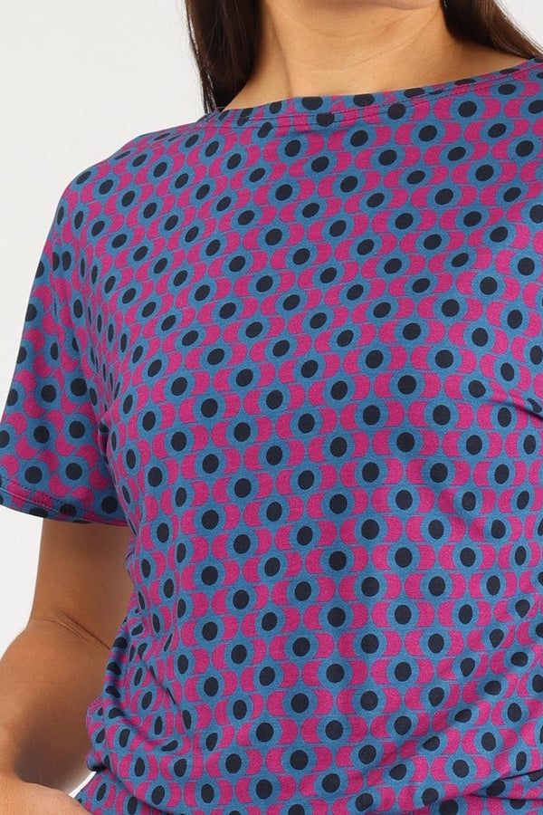 Kurzärmliger Damen-Jumpsuit in Lila mit dunkelblauem Polka-Dot-Muster und weitem Bein im Culotte-Stil.