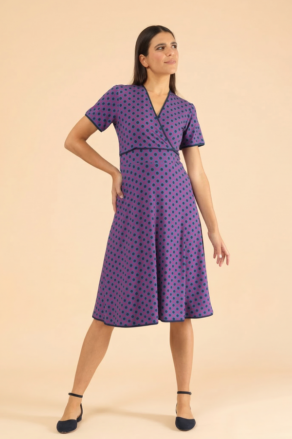 Lila Kurzarm-Wickelkleid für Damen mit dunkelblauem Punktemuster und ausgestelltem Rock.