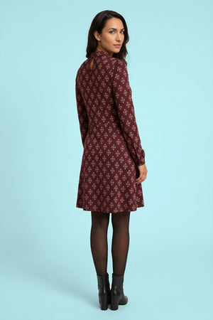 Model trägt das Kleid Astrid Burgundy Nexus – Ganzkörperansicht (2. Ansicht)